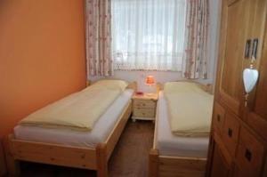 Duas camas num pequeno quarto com uma janela em Ferienwohnung Tschaneck für 6 Personen mit Top-Ausstattung 