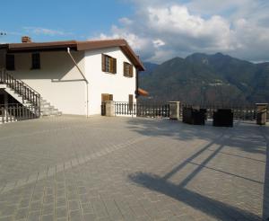 a white building with mountains in the background at A. F.antastic V.iew in Costa Volpino