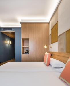 a bedroom with a large white bed and wooden walls at Principe Pio in Madrid