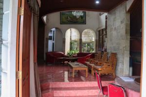 a living room with chairs and a table and a couch at Villa saung panenjoan in Puncak