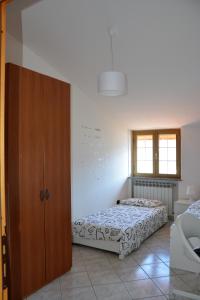 1 dormitorio con 1 cama y armario de madera en A. F.antastic V.iew, en Costa Volpino