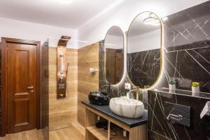 baño con lavabo y 2 espejos en Chalet jolie Luxury Vila Sinaia en Sinaia