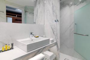 a white bathroom with a sink and a shower at Athens Marriott Hotel in Athens