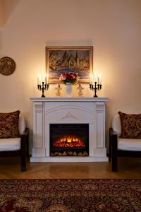 a fireplace in a living room with two chairs and candles at FLEUR DE LIS HOTEL in Prague