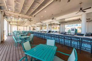 南帕諸島的住宿－Courtyard South Padre Island，一间设有蓝色桌椅的自助餐厅和一间酒吧