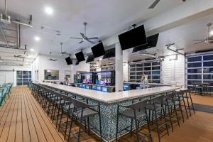 un bar en un restaurante con sillas y TV en Courtyard South Padre Island en South Padre Island