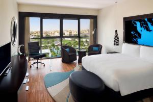 アブダビにあるマリオット ホテル アル フォルサン アブダビのベッドと大きな窓が備わるホテルルームです。