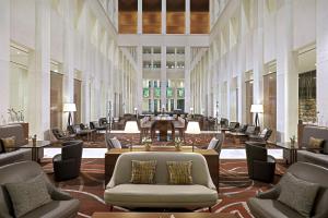 eine große Lobby mit Stühlen und Tischen in einem Gebäude in der Unterkunft Berlin Marriott Hotel in Berlin