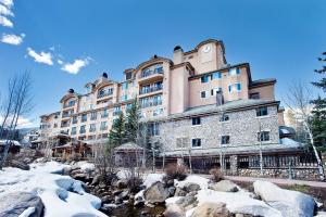 a large building with a river in front of it at Beaver Creek Lodge, Autograph Collection in Beaver Creek