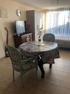 a room with a table and two chairs and a television at Studio pour 2 personnes à Tonnay Charente in Tonnay-Charente