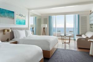 um quarto de hotel com duas camas e um sofá em The Ritz-Carlton, Fort Lauderdale em Fort Lauderdale