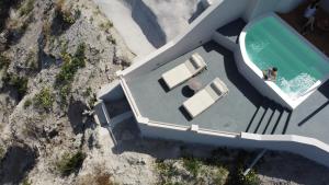 an overhead view of a pool with two people in the water at Grand View - Megalochori Santorini in Megalochori