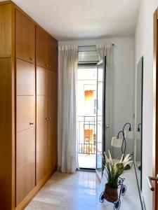 a living room with a window and a plant on the floor at Suite Apartment City Center - Aloha Sevilla in Seville