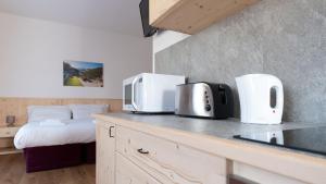 a kitchen with a counter with a microwave and a bed at Italianway - Ripa Fontana 1 Mono in Valdidentro