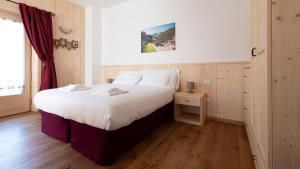 Un dormitorio con una gran cama blanca y una ventana en Italianway - Ripa Fontana 1 Mono, en Valdidentro