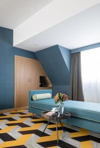 a living room with a blue couch and a table at Principe Pio in Madrid