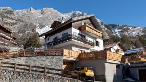 a house with a yellow van parked in front of it at Italianway - Ripa Fontana 1 Mono in Valdidentro