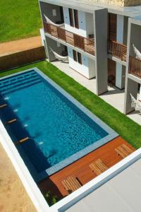 a swimming pool in the backyard of a house at Pousada Praia do Patacho in Pôrto de Pedras