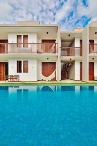 a villa with a swimming pool in front of a house at Pousada Praia do Patacho in Pôrto de Pedras