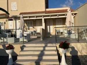 a house with two white vases with flowers on the stairs at L'Aurora Tropea in Torre Marino