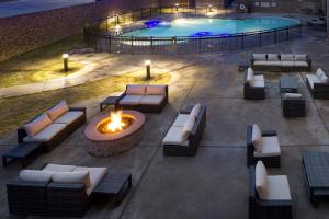 une terrasse avec un foyer extérieur et une piscine dans l'établissement Courtyard by Marriott Dallas DFW Airport North/Grapevine, à Grapevine