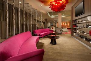 een woonkamer met roze meubels en een kroonluchter bij Courtyard by Marriott Dallas DFW Airport North/Grapevine in Grapevine