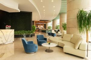 a lobby with a couch and chairs and a table at Four Points By Sheraton Kuwait in Kuwait