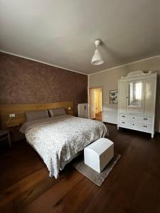 a bedroom with a large bed and a white dresser at La Maison Apartment in Fanano
