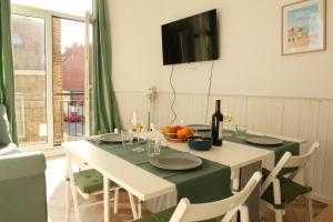 a dining room with a table with a bottle of wine at "Pieds dans l'eau", Dunkerque plage, digue de mer Malo les bains, T2 in Dunkerque