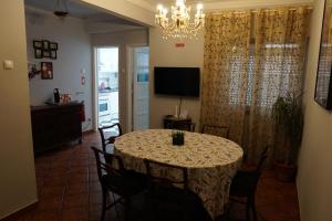 a dining room with a table with chairs and a chandelier at Herois Apartment in Damaia