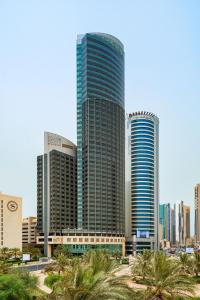 un groupe de grands bâtiments dans une ville avec des palmiers dans l'établissement Four Points By Sheraton Kuwait, à Koweït