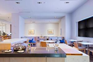 a restaurant with tables and chairs and a flat screen tv at Marriott Orlando Downtown in Orlando