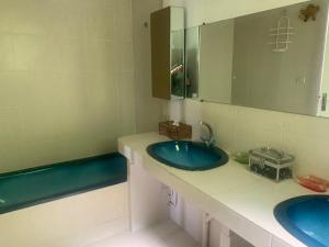 a bathroom with two blue sinks and a mirror at Loustalou in Saint-Tropez
