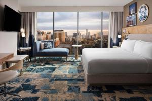 a hotel room with a bed and a view of a city at The Otis Hotel Austin, Autograph Collection in Austin