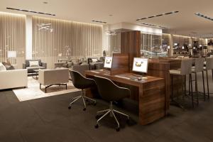 a lobby with a counter and chairs and a bar at AC Hotel by Marriott Milan Sesto in Sesto San Giovanni
