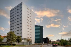 un edificio blanco alto al lado de una calle en AC Hotel by Marriott Milan Sesto en Sesto San Giovanni