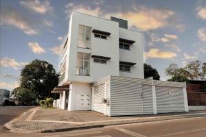 a white building with a fence in front of it at Apartamento em foz do Iguaçu in Foz do Iguaçu