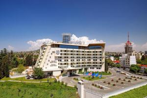 a hotel building with a road in front of it at Sheraton Grand Tbilisi Metechi Palace in Tbilisi City