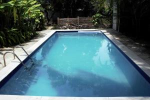 una piscina de agua azul en un patio en Casa temporada ampla e confortável em Olinda, en Olinda
