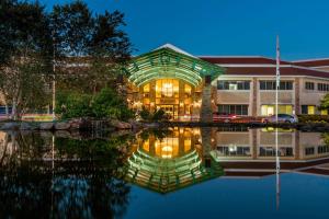 Auburn Marriott Opelika Resort & Spa at Grand National في أوبيليكا: مبنى فيه انعكاس للمياه ليلا