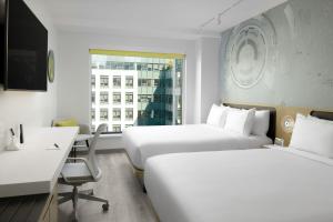una camera d'albergo con 2 letti e una scrivania di Astra Hotel, Seattle, a Tribute Portfolio Hotel by Marriott a Seattle