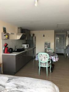 a kitchen with two chairs and a table and a counter at Studio pour 2 personnes à Tonnay Charente in Tonnay-Charente