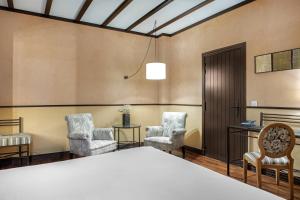 a room with a bed and two chairs and a table at AC Hotel Ciudad de Tudela by Marriott in Tudela