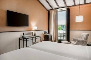 a hotel room with a bed and a tv at AC Hotel Ciudad de Tudela by Marriott in Tudela