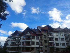 an apartment building with a blue sky in the background at Premium mountain studio 40 Semiramida Gardens in Borovets