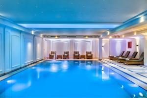 ein großer Pool in einem Gebäude mit Stühlen in der Unterkunft JW Marriott Hotel Berlin in Berlin