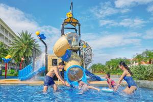 a group of people in the water at a water park at Sheraton Grand Danang Resort & Convention Center in Danang