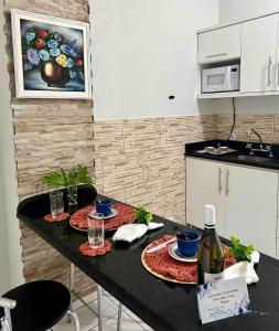 una cocina con una mesa con dos platos y copas de vino en Loft em Foz do Iguaçu, en Foz do Iguaçu