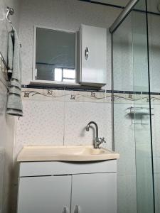 une salle de bain avec un lavabo et une fenêtre dans l'établissement Loft em Foz do Iguaçu, à Foz do Iguaçu
