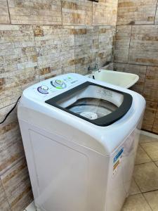 y baño con lavabo y lavadora. en Loft em Foz do Iguaçu, en Foz do Iguaçu